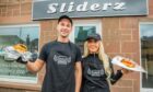 A man and a woman standing outside Sliderz on Perth Street, Blairgowrie holding a burger each