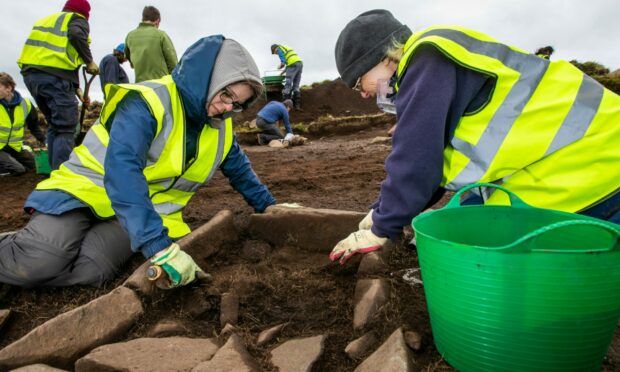 Karen Stewart-Russell from Star and Esther Hunter from Kinneswood (both volunteers) excavate a hearth on East Lomond. Image: Steve Brown/DC Thomson