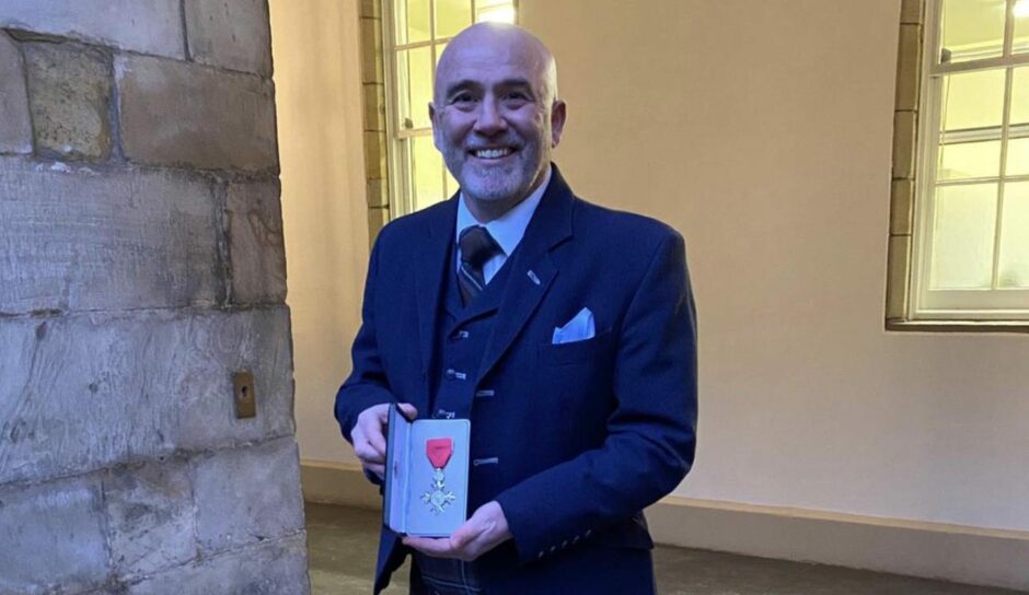 Dougie Samuel is pictured with his MBE at the Palace of Holyroodhouse in Edinburgh