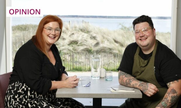 MasterChef winner Jamie Scott and wife Kelly seated at a restaurant table by a window with view of Broughty Ferry beach and the Tay estuary beyond.