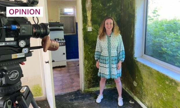 Martel Maxwell grimacing for the TV cameras inside a house with walls covered in green mould while filming for TV's Under the Hammer show.