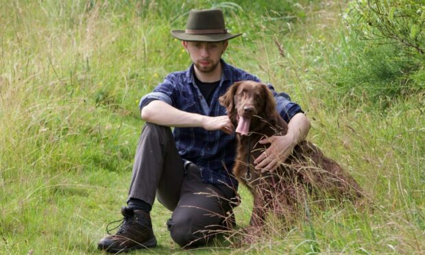 Will Kent kneeling with his dog.