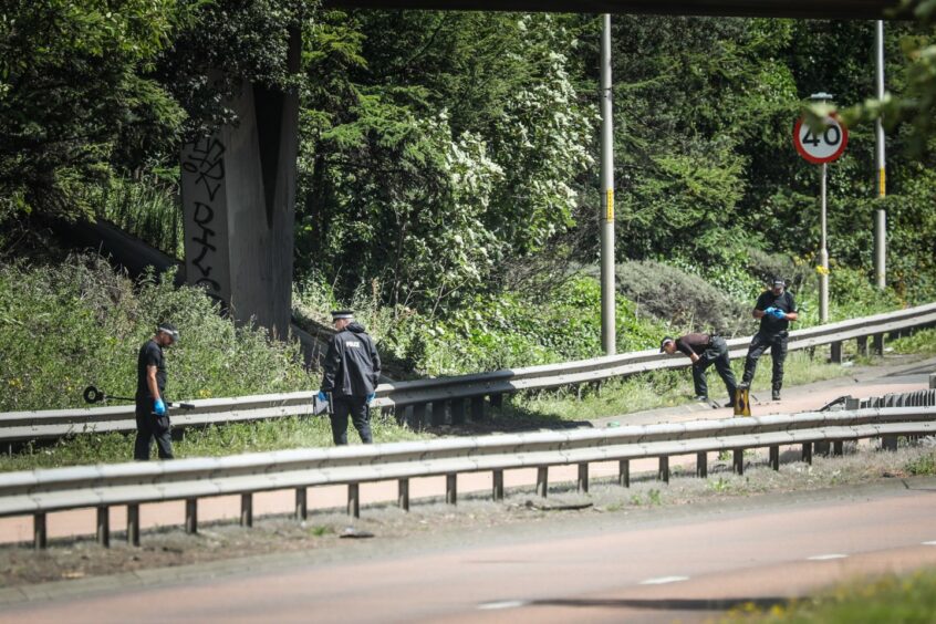 Officers examining the scene on the Kingsway