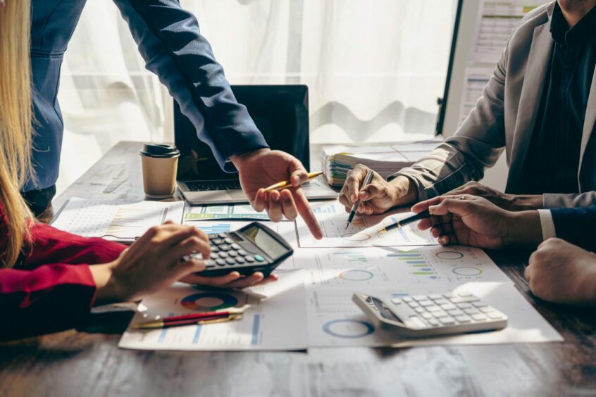 Business people working on a deal and analysing reports.