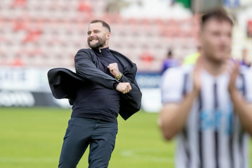 Dunfermline manager James McPake punches the air in celebration.