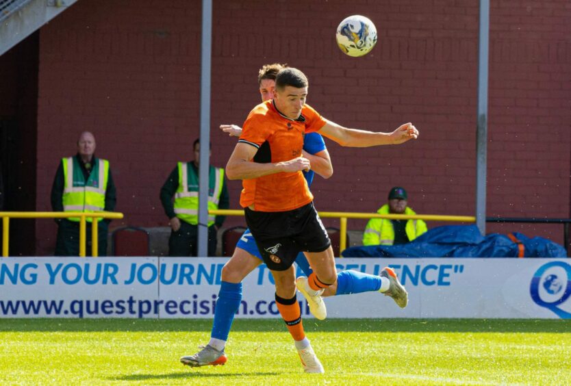 Ross Graham wins a header during Dundee United's Viaplay Cup win over Peterhead