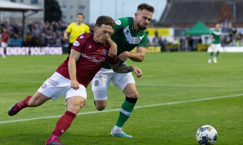 Dundee United defender Scott McMann dispossess Ricky Little at Gayfield