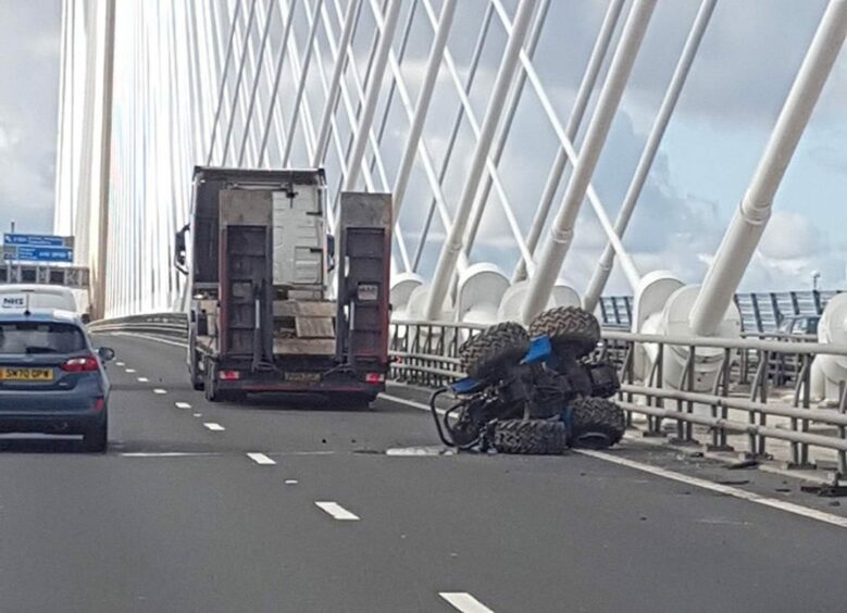 The tractor off the back of a lorry on the Queensferry Crossing.