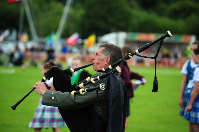 A piper marches in at The Inverkeithing Highland Games