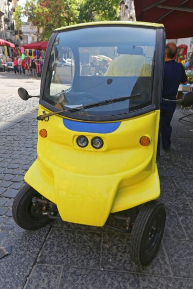 yellow electric micro car parked on a street