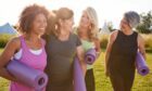 group of female friends walking outdoors carrying yoga mats