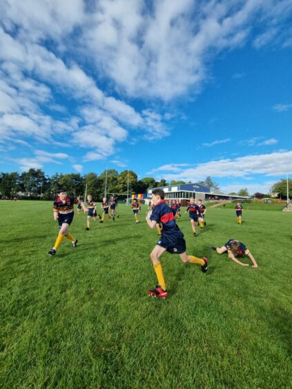 High School of Dundee student rugby team playing a game outside.