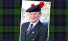 Fred Beattie is photographed against a backdrop of Black Watch tartan.