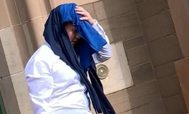 George Ramsay covered his face as he left Forfar Sheriff Court.