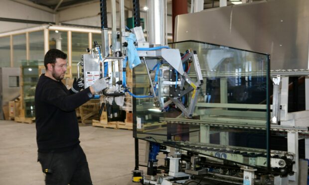 A worker transferring glass with suction cup machines at Ravensby Glass. Image: Gareth Jennings/DC Thomson.