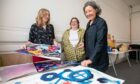 Image shows artists Anna Kelso, Caitlyn Hanna and Helen O'Brien standing behind some of the art work they have made at Creative Catalyst in Perth.