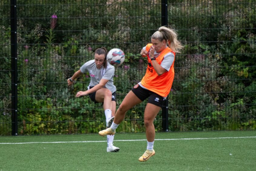 Robyn Smith is closed down by Katie Frew, in bib, during Dundee United training