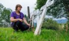 Alexa Reid kneeling next to grave markers at the Auchingarrich wildlife centre pet cemetery.