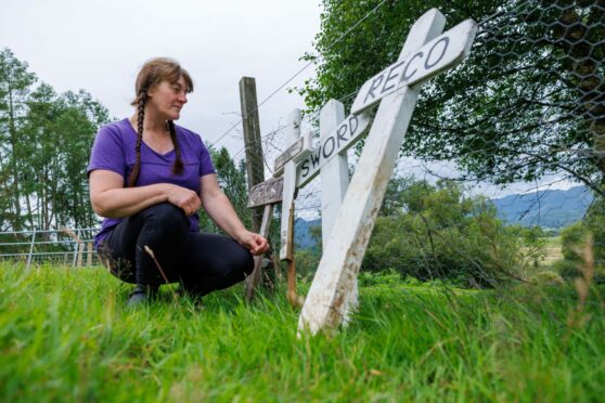 Alexa Reid kneeling next to grave markers at the Auchingarrich wildlife centre pet cemetery.