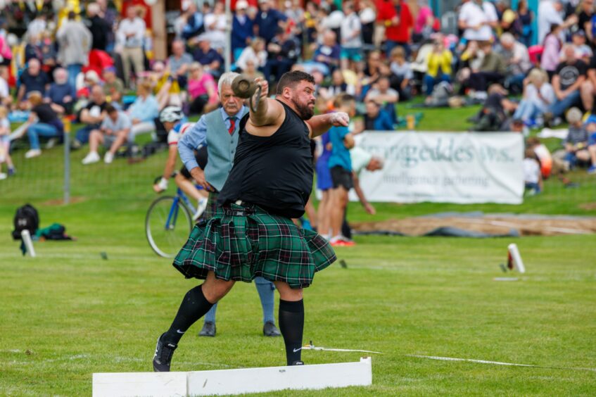 Kilted heavyweight athlete throwing the hammer at Crieff Highland Gathering.