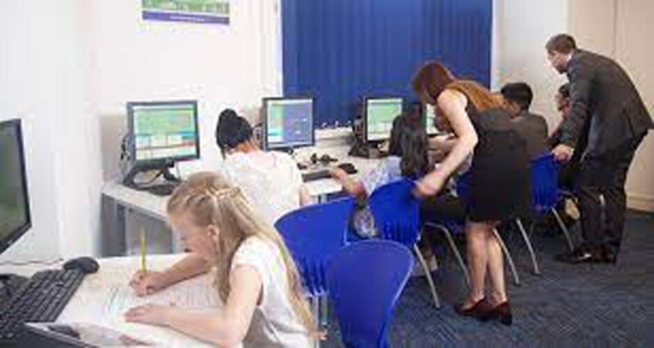 Children studying in a classroom at their computer desks at Kip McGrath which provides support for parents in the UK