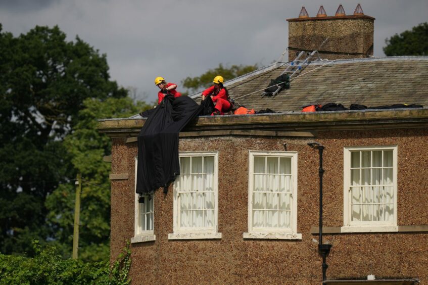 Greenpeace activists moving fabric on the roof of Prime Minister Rishi Sunak's house in Richmond, North Yorkshire
