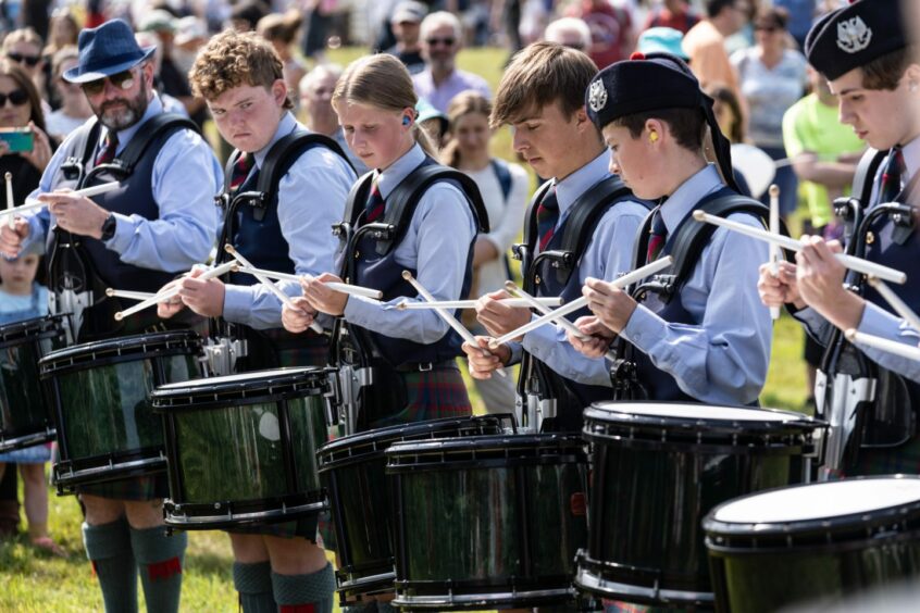 Young pipe band musicians playing drums at Perth Highland Games in 2022.