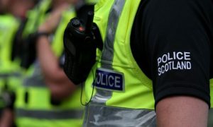 Generic image of police officer, showing sleeve with Police Scotland logo.