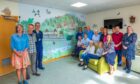Patients, staff and visitors beside the new mural at Crieff Community Hospital.