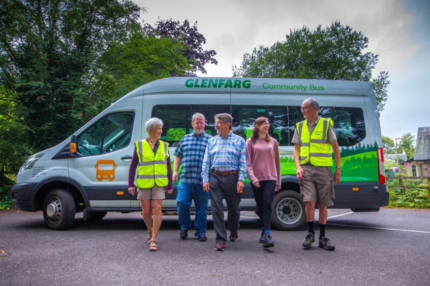 Five volunteers walking away from a minibus with 'Glenfarg community Bus' livery
