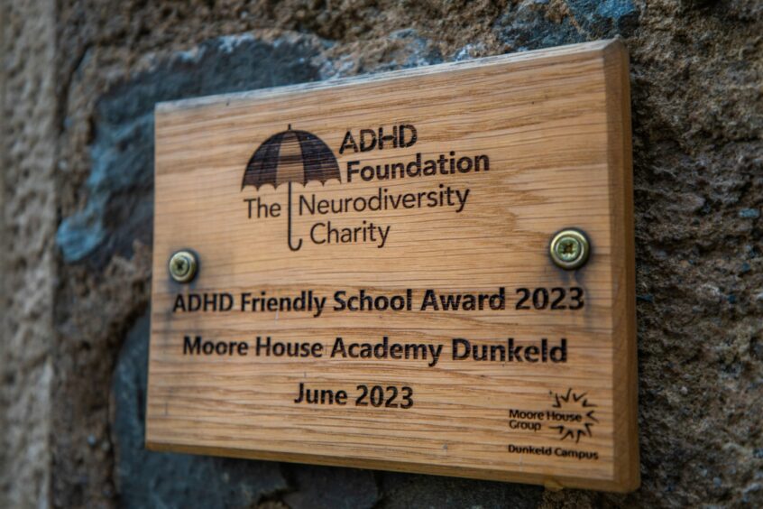 Wooden plaque celebrating ADHD-friendly school award 2023, granted to Moore House Academy Dunkeld in June 2023 by the ADHD Foundation.
