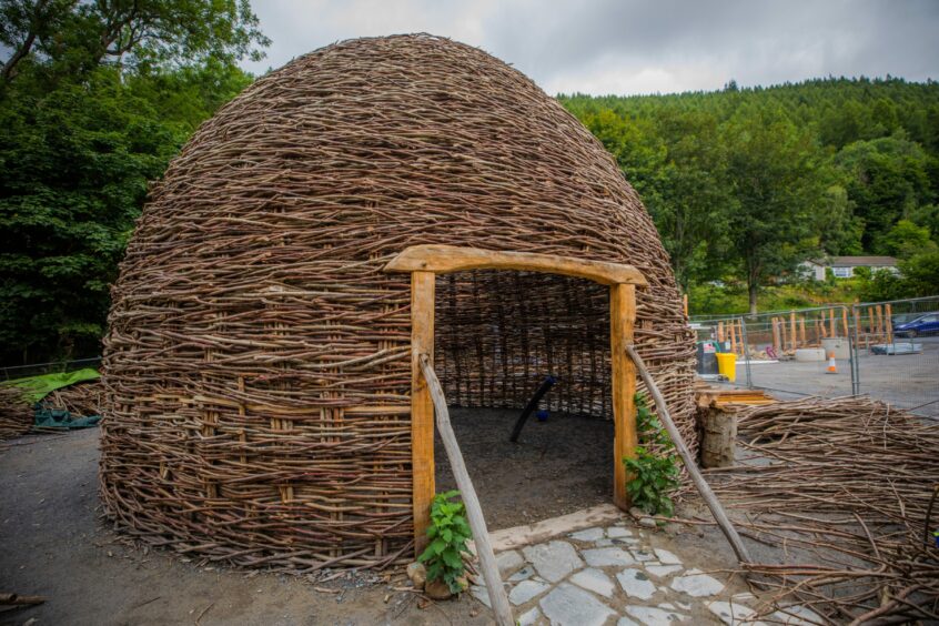 round wooden building woven from hazel branches.