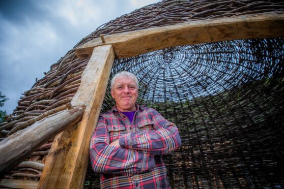 Scottish Crannog Centre director Mike Benson standing at the entrance to a large wooden structure at the museum's new base near Kenmore.