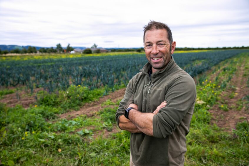 Farmer Derek Alexander standing in front of his vegetable field.