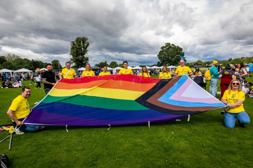 Perth Pride participants with large rainbow flag.