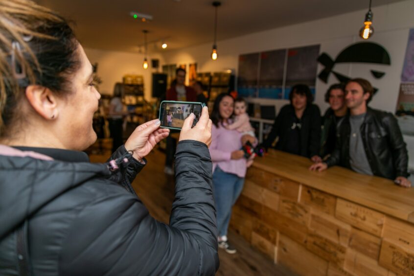 Fan takes a photo of the band at record shop event in Dundee.