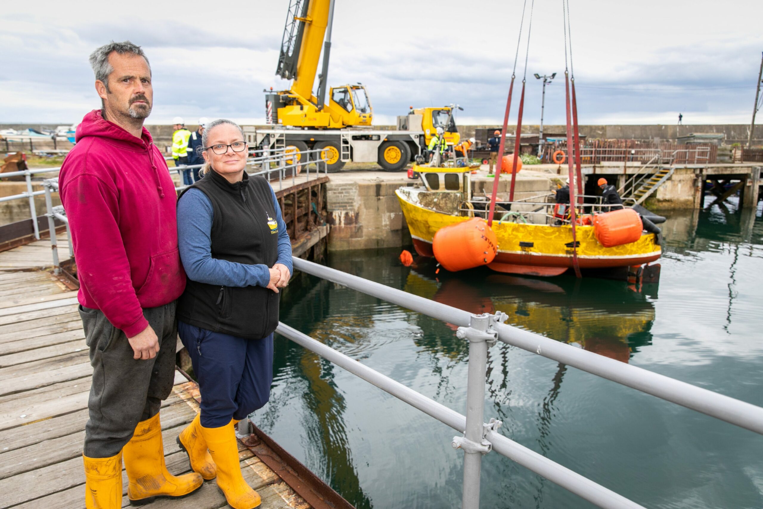 Ross and Tina observe the Tina Louise being lifted from the water after being sunk in July 2023. 