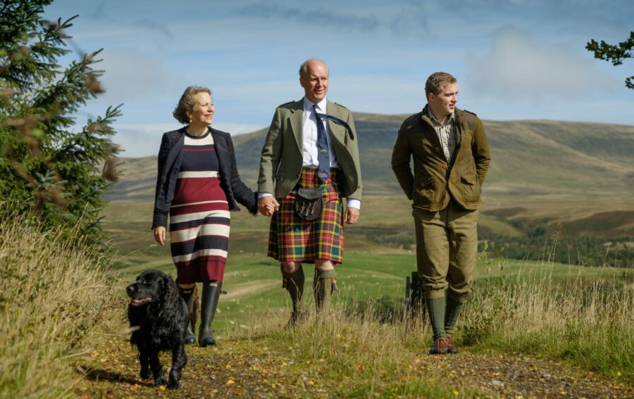 The Buchanan, the Lady Buchanan &amp; their son Bruce walking in a field
