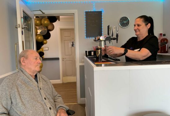 Wendy Parker serving care home resident, Jim Peebles at the new Back n' Forth in-house pub.