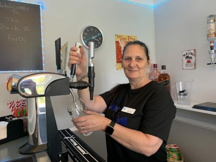 Care home team leader Wendy Parker pulls a pint at the new in-house pub. 