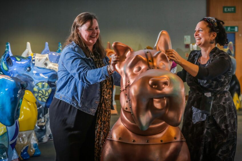 Project manager Jane Kennedy and artist co-ordinator Rio Moore (right) with Copper Dog by John Fairley.