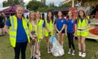 Seven members of Perth City Swim Club with litter picking gear at Crieff Highland Gathering.
