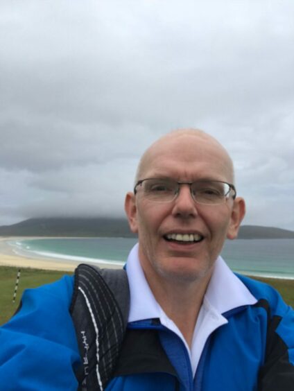 A smiling Iain Ross from Blairgowrie at a beach.