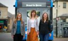 Sarah Elliot of Stagecoach, Roxanne Kerr of Trauma Healing Together and Rachael Prothero of Paths for All, standing in front of a Stagecoach bus.