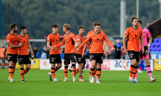 Delirious Dundee United players go to take the acclaim of the travelling fans