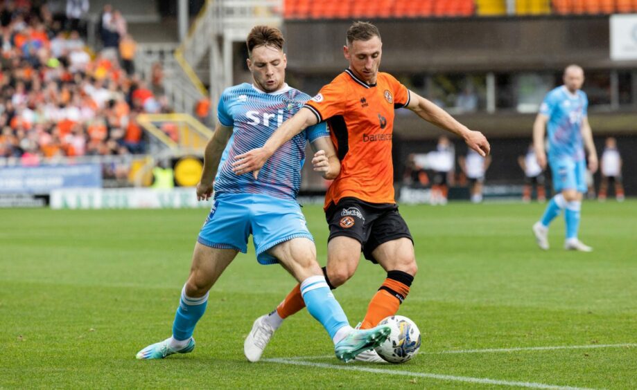 Dunfermline Athletic F.C. defender Josh Edwards stretches out his left boot to tackle Dundee United striker Louis Moult.