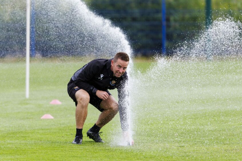 St Johnstone manager Steven MacLean deals with a sprinkler during training. 