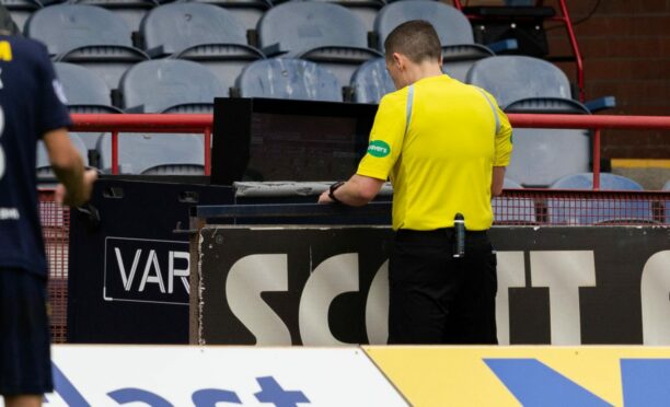 Referee David Munro goes to the VAR monitor. Image: SNS
