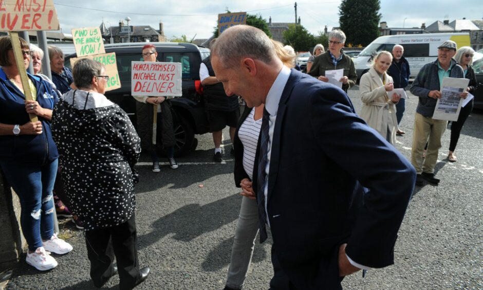 Mr Matheson passes protesters as he arrives at Lochgelly Health Centre.