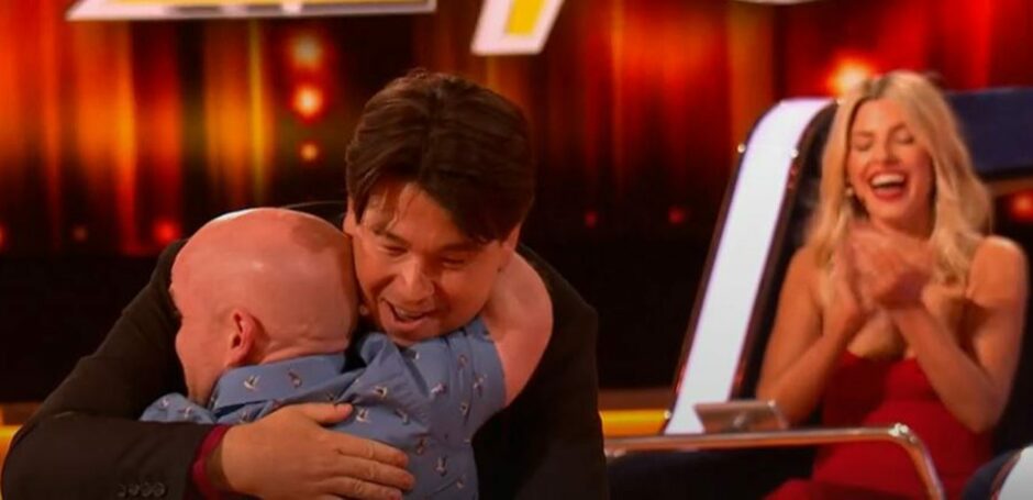 Colin Brown from Kirkcaldy in Fife celebrates with Michael McIntyre and Mollie King after winning The Wheel